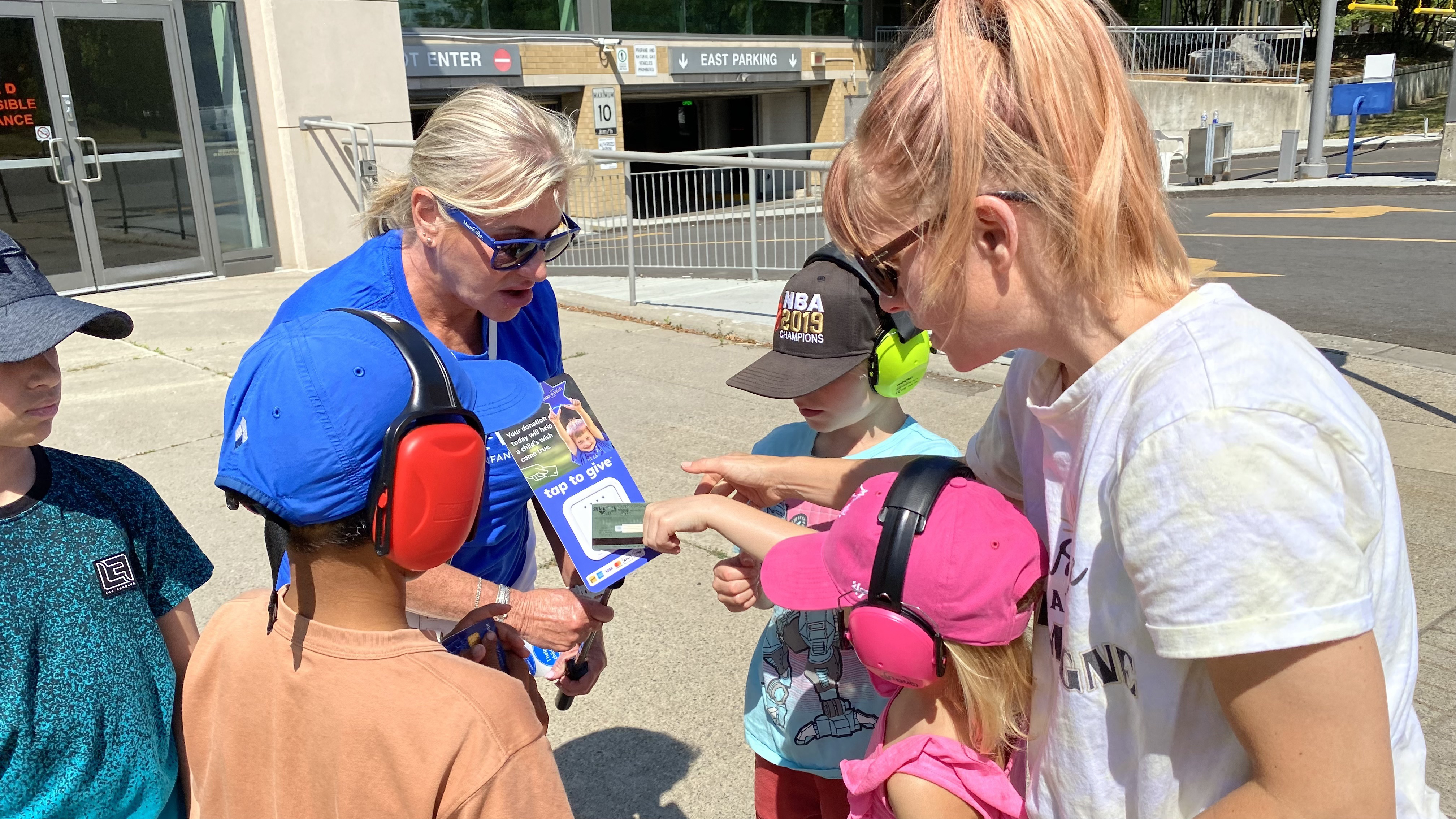 A Make-a-Wish volunteers accepts a donation from race fans